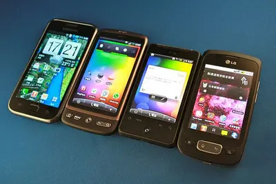 Four vintage early-2010s Android phones from Samsung, HTC and LG lined up side by side