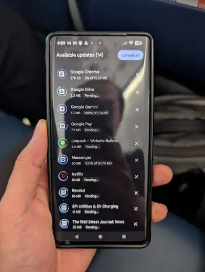 Google Play Store showing a list of apps with available updates downloading